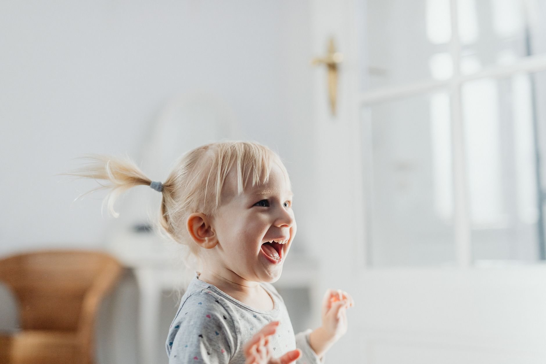 Cute blonde toddler laughing with joy